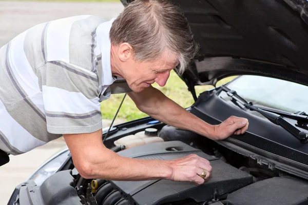 Ervaren bestuurder check-up een oliepeil in auto motor — Stockfoto