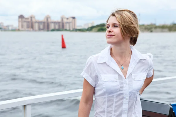 Chica joven de pie en la cubierta del barco y mirando hacia otro lado — Foto de Stock