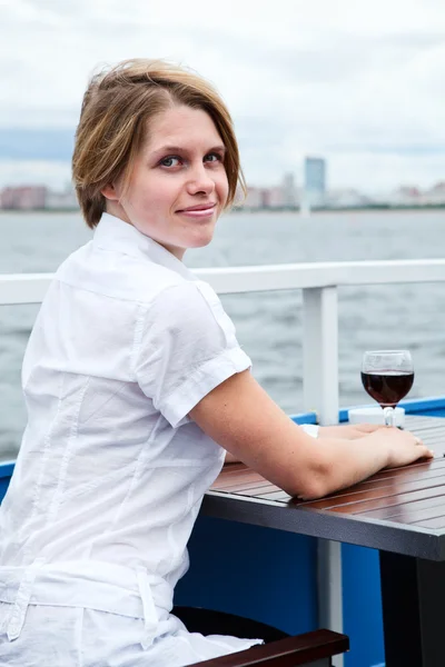 Při pohledu od zadní žena se červené víno, sedící u stolu café — Stock fotografie