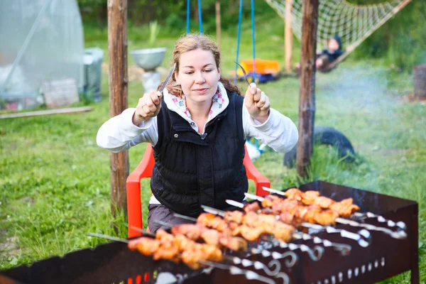 Hungry young female with fork and knife in hands sitting and waiting for grill meat — Stock Photo, Image