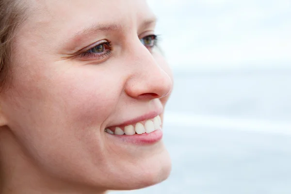 Cerca de la cara de una mujer hermosa en el perfil con dulce sonrisa. Copyspace — Foto de Stock