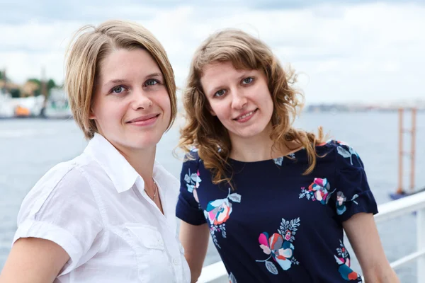 Group portrait of two smiling beautiful women standing together on vessel deck — Stock Photo, Image