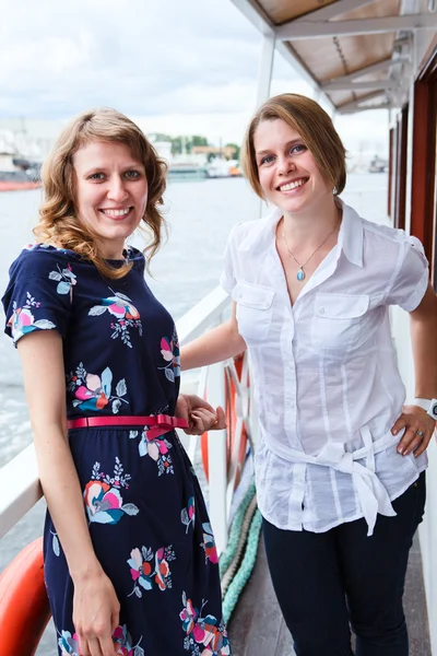 Mulheres atraentes felizes em pé no convés do navio durante o cruzeiro marítimo — Fotografia de Stock