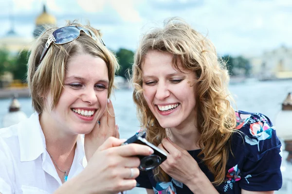 Zwei fröhliche Schönheitsfrauen, die auf den Bildschirm einer einfachen Handkamera blicken — Stockfoto