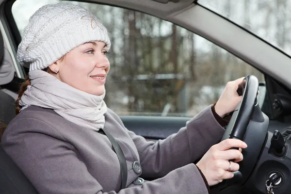 Žena v zimní oblečení řídit auto — Stock fotografie