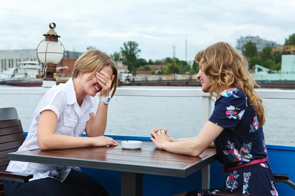 Two girlfriends talking each other at cafe table outdoors — Stock Photo, Image