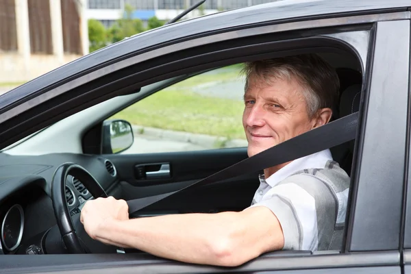 Happy Caucasian senior man fastens safety belt sitting in car on driver seat — Stock Photo, Image