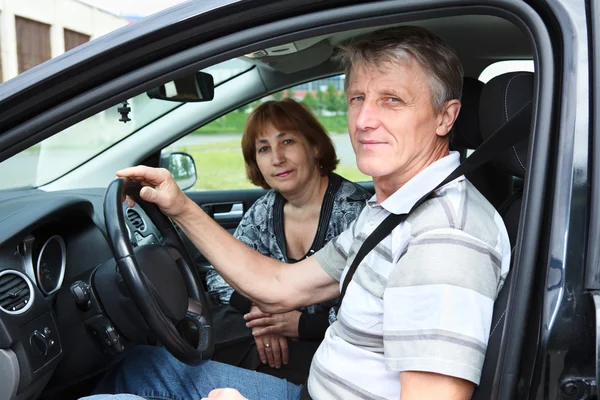 Homem e mulher caucasianos sênior sentados em veículo terrestre e sorrindo — Fotografia de Stock