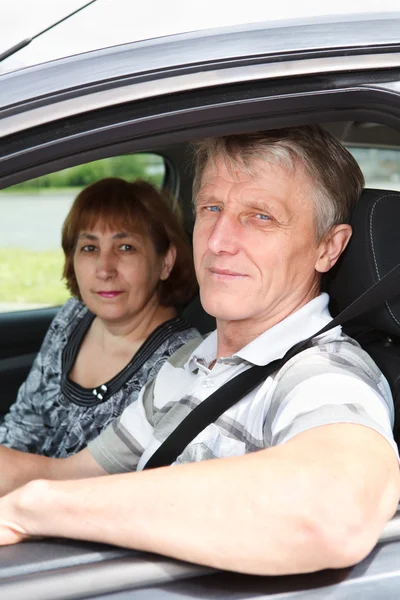 Gros plan de couple caucasien âgé assis dans une voiture domestique et souriant — Photo