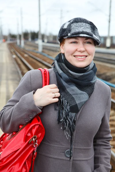 Tren istasyonu üzerinde duran mutlu moda genç beyaz kadın portresi. uzak bakıyor. kopya alanı — Stok fotoğraf
