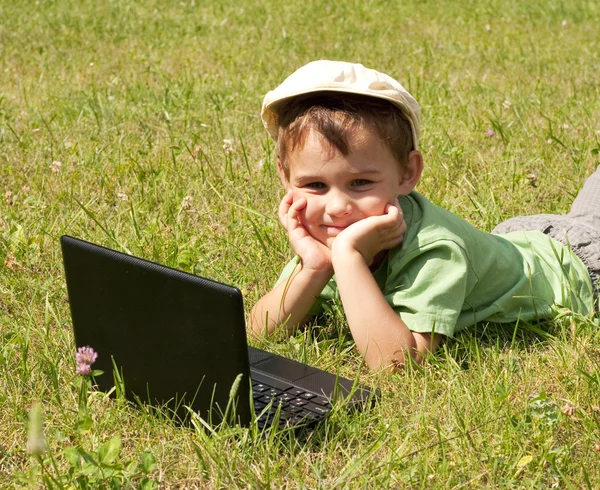 stock image Kid with laptop on green meadow