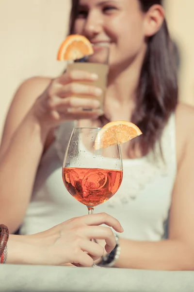 Fröhliche junge Frau trinkt mit kaltem Getränk im Vordergrund — Stockfoto