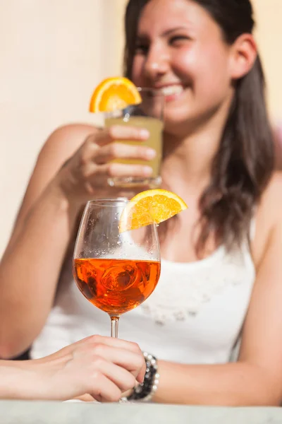 Gelukkig jonge vrouw drinken met koud drankje op voorgrond — Stockfoto
