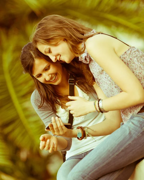 Две красивые женщины отправляют сообщения с мобильного телефона — стоковое фото