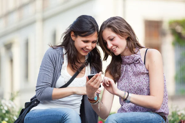 Dvě krásné ženy odesílání zpráv s mobile Stock Snímky
