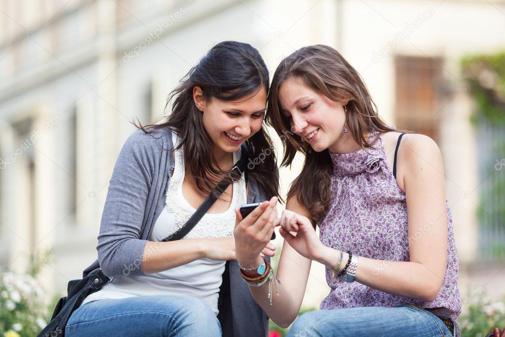 Two Beautiful Women Sending Messages with Mobile
