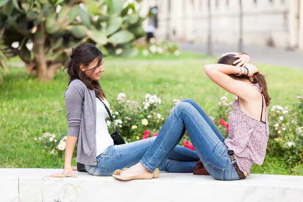 Twee jonge vrouwen op een bankje in het park — Stockfoto