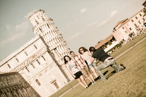 Grupo de amigos tomando fotos con Pisa torre inclinada en el fondo — Foto de Stock
