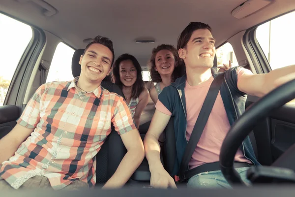 Vier Freunde im Auto auf dem Weg in den Urlaub — Stockfoto