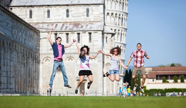 Groep vrienden springen met scheve toren van pisa op achtergrond — Stockfoto