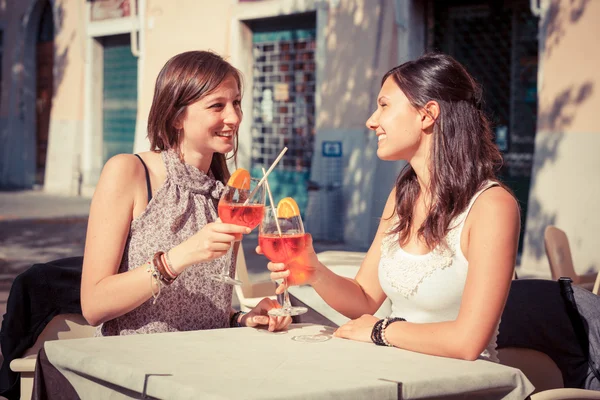 Zwei junge Frauen jubeln mit kalten Getränken — Stockfoto