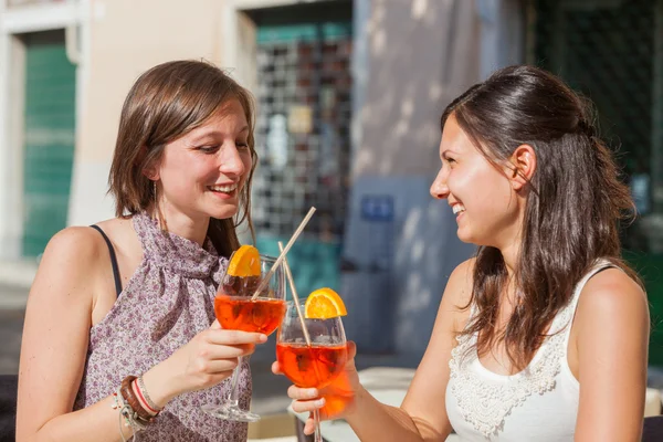 Duas jovens mulheres torcendo com bebidas frias — Fotografia de Stock