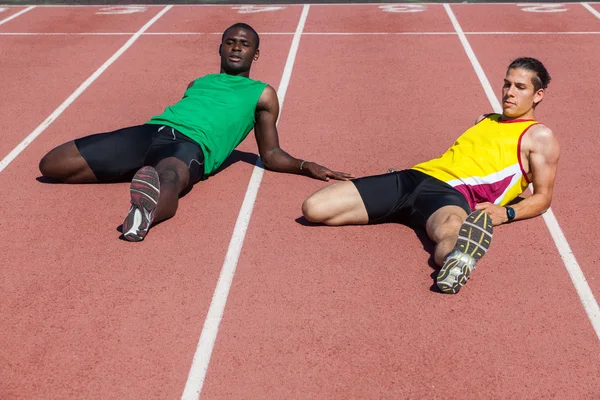 Two Track and Field Athletes Stretching — Stock Photo, Image