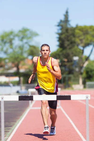 Atleta de pista y campo masculino durante la carrera de obstáculos — Foto de Stock