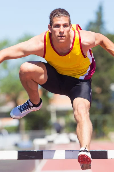 Pista masculina e atleta de campo durante a corrida de obstáculos — Fotografia de Stock