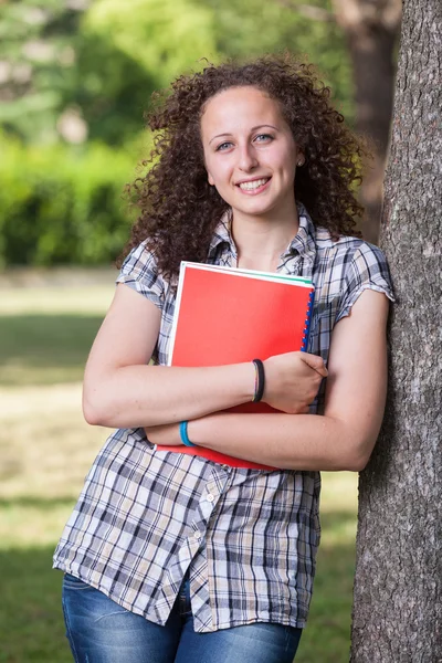 Jonge mooie vrouwelijke student in het park — Stockfoto