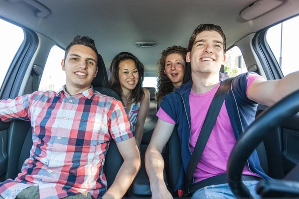 Quatro amigos em um carro que parte para férias — Fotografia de Stock