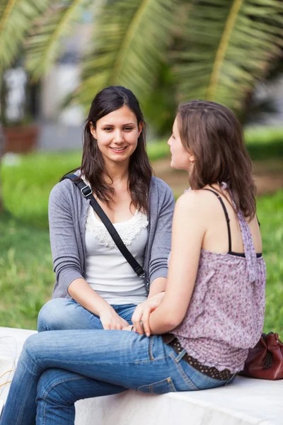 Zwei junge Frauen auf einer Parkbank — Stockfoto