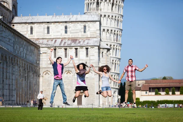 Groep vrienden springen met scheve toren van pisa op achtergrond — Stockfoto