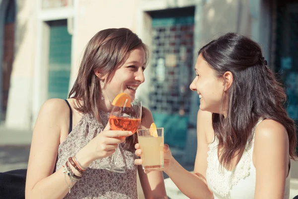 Två unga kvinnor jublar med kalla drycker — Stockfoto
