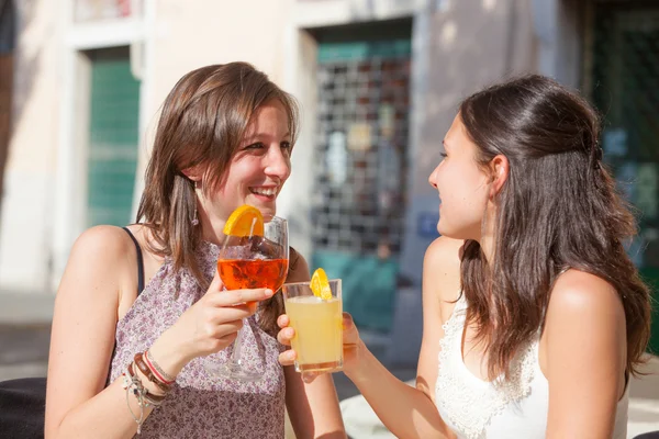 Duas jovens mulheres torcendo com bebidas frias — Fotografia de Stock