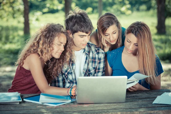 Groep tiener studenten bij park met computer en boeken — Stockfoto