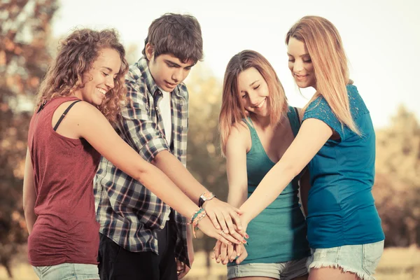 Skupina teenagerů s rukama na zásobníku — Stock fotografie