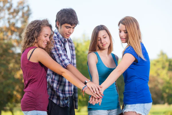 Groep van tieners met handen op stapel — Stockfoto
