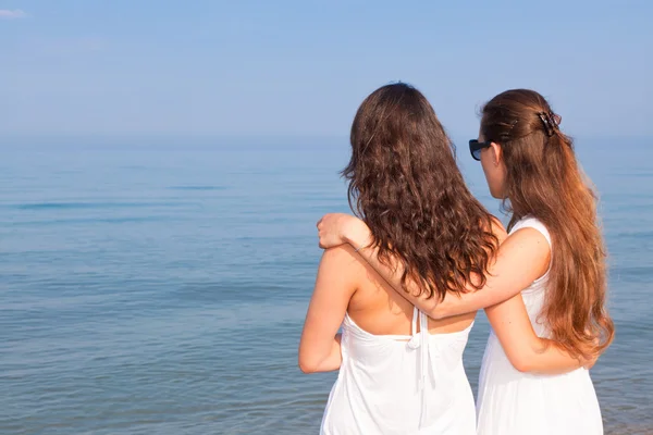 Dos amigas abrazadas en la playa — Foto de Stock