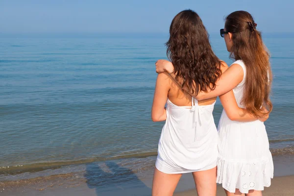Две подруги обнялись на пляже — стоковое фото