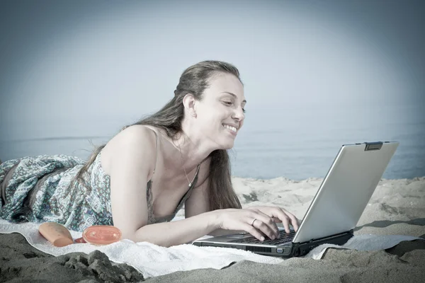 Femme travaillant à l'ordinateur sur la plage — Photo