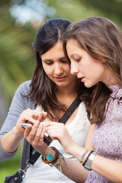 Dvě krásné ženy odesílání zpráv s mobile — Stock fotografie