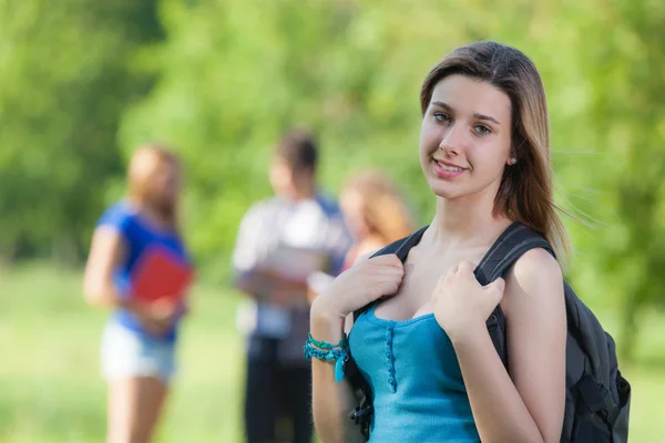 Giovane studentessa al parco con altri amici — Foto Stock