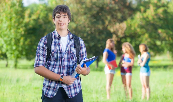 Молодой парень-студент с друзьями в парке — стоковое фото