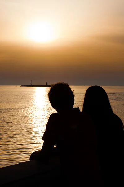 หนุ่มสาว คู่ สีลูเอท ที่ Sunset — ภาพถ่ายสต็อก