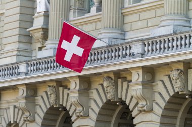 Bundeshaus Facade with Swiss Flag in Bern, Switzerland clipart