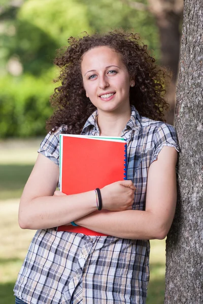 Jonge mooie vrouwelijke student in het park — Stockfoto