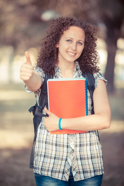 Mladá krásná studentka s palcem nahoru — Stock fotografie