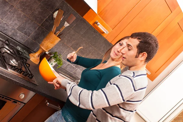 Muž se snaží ochutnat něco v kuchyni — Stock fotografie
