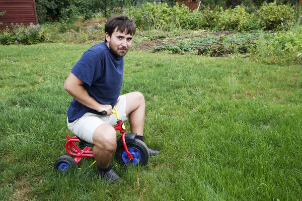 Homem adulto em um pequeno triciclo — Fotografia de Stock